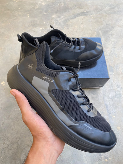 Black mesh fashion sneakers with thick cushioned soles and a toggle lace system